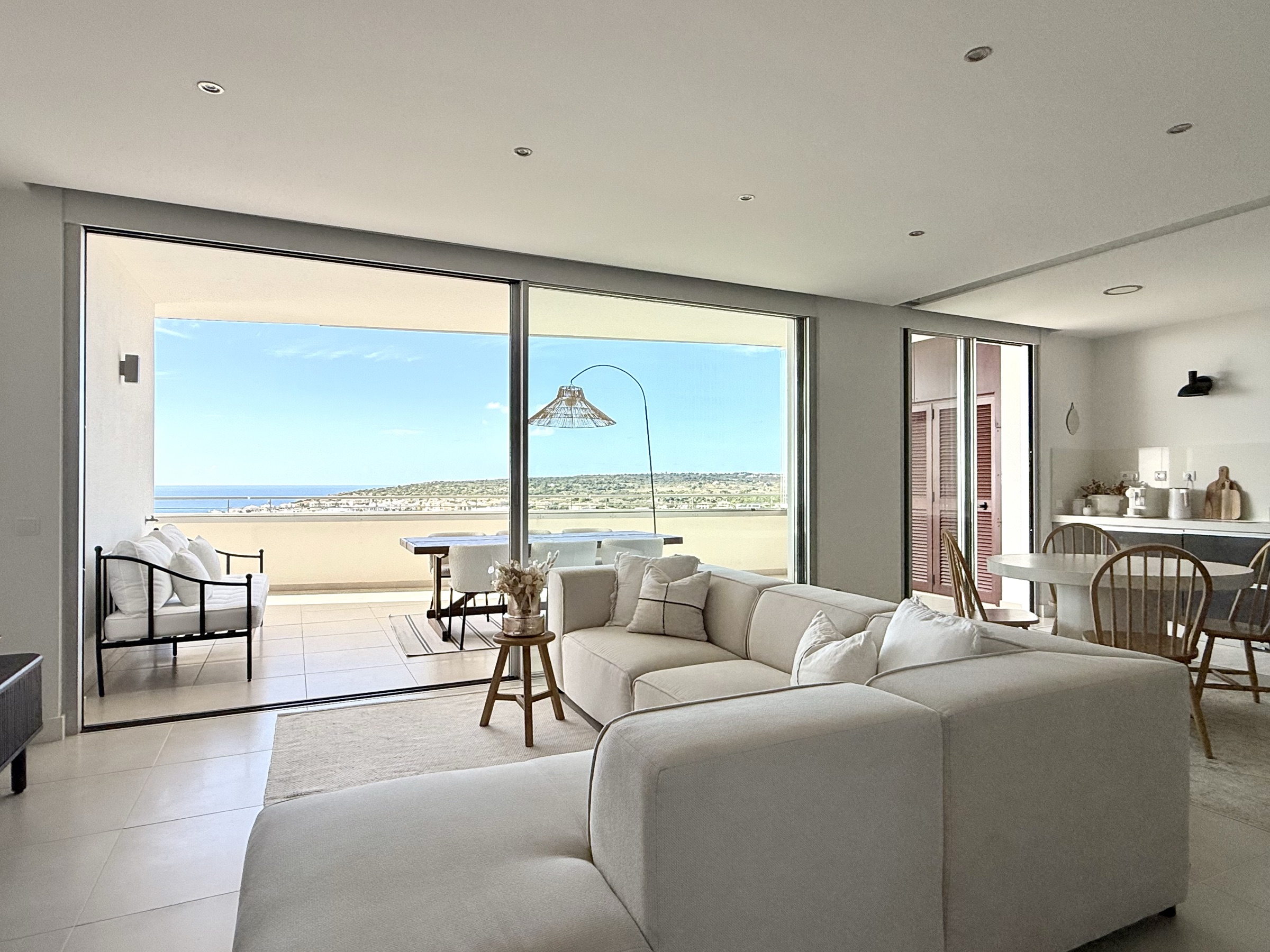 Sunlit open-plan living room opening to a terrace and Atlantic Ocean view