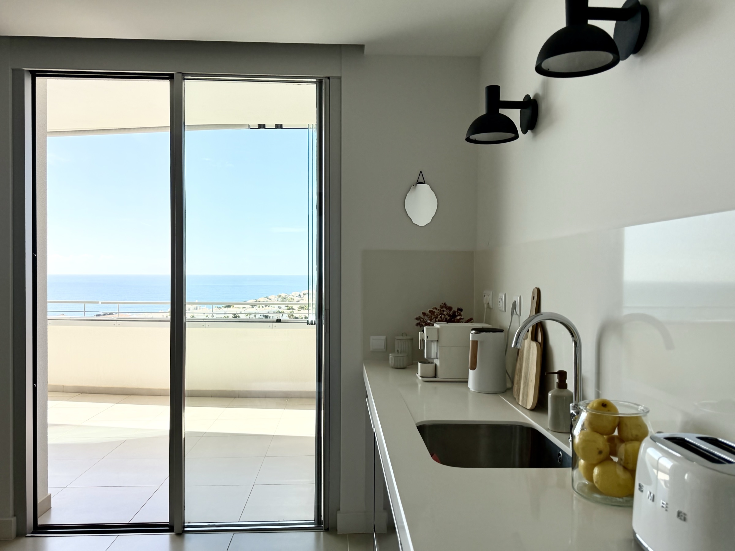 Kitchen opening directly to the ocean-facing terrace