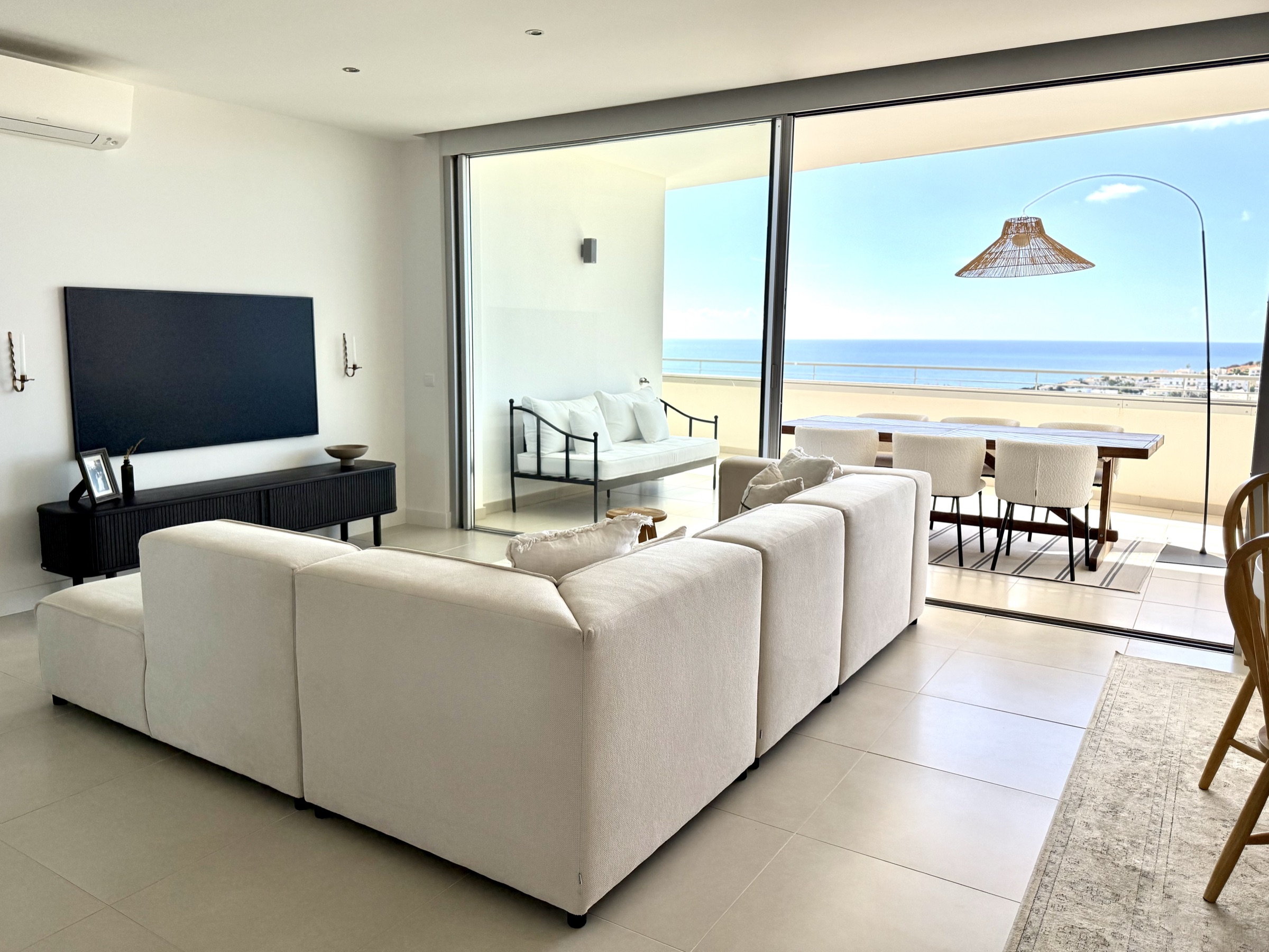 Living room opening fully to the ocean-facing terrace